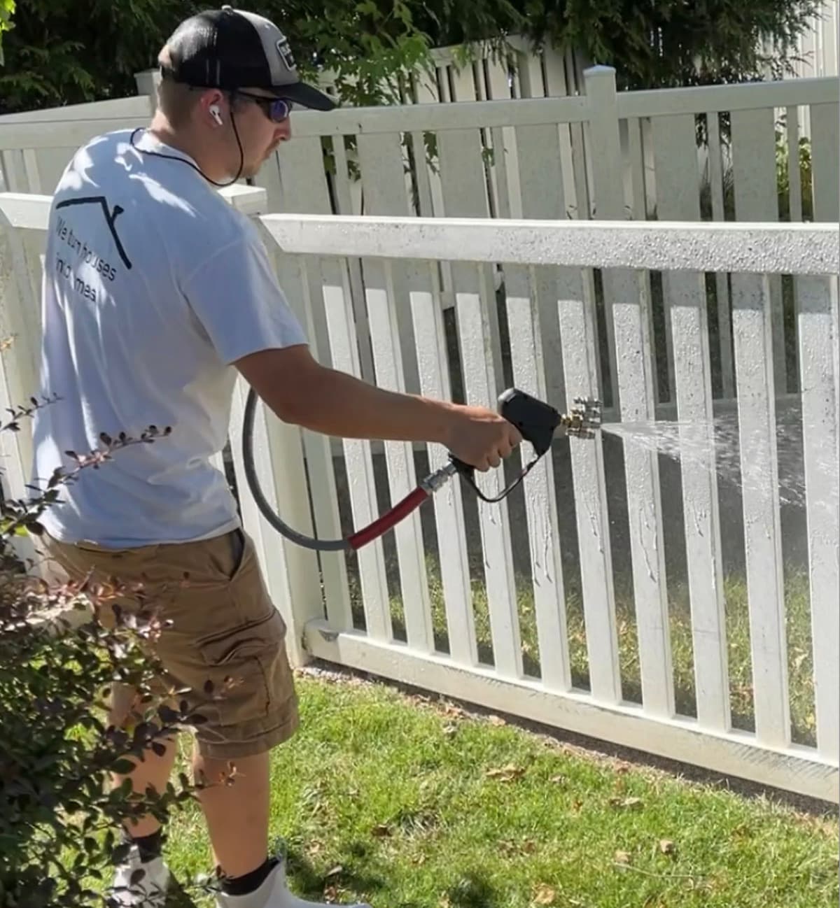 ATC technician washing a white vinyl fence