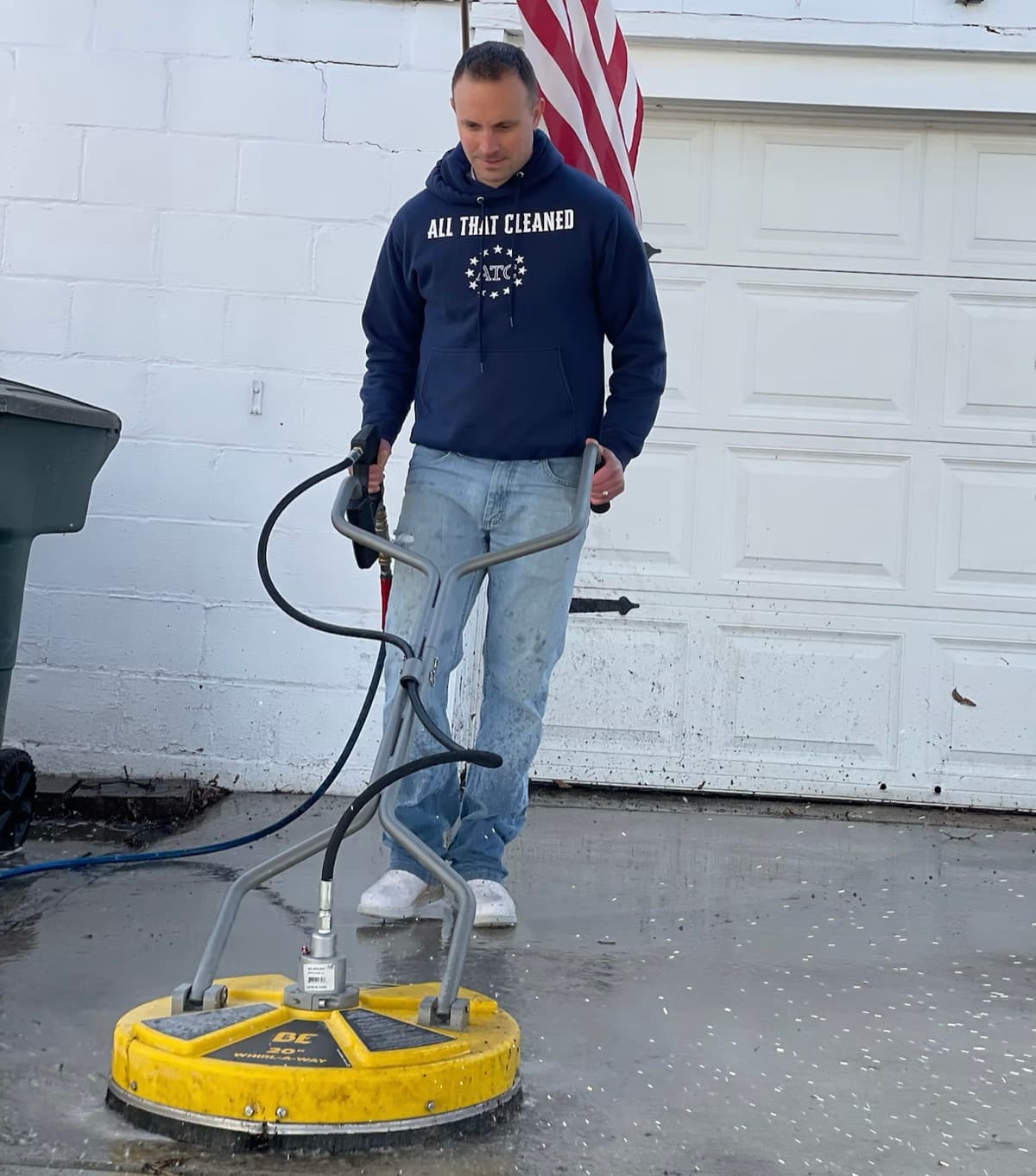 ATC crew member using a surface cleaner on residential concrete